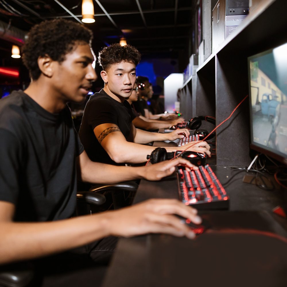 A deep upholstered armchair angled toward a gaming PC with a side table